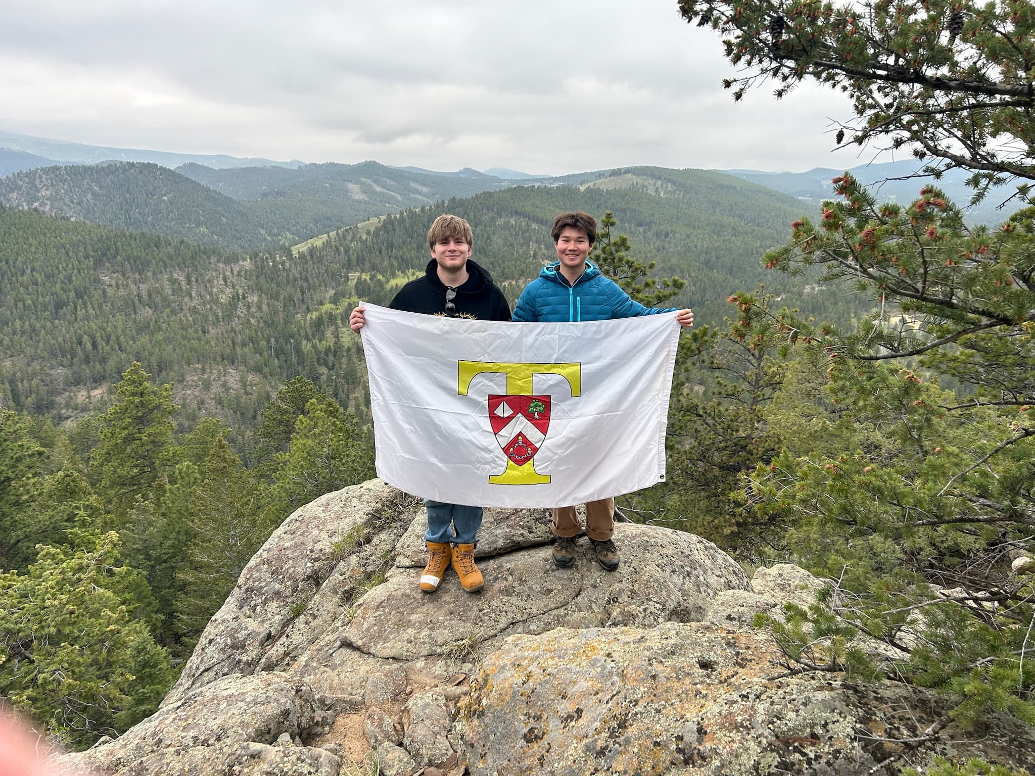 Brothers with Triangle flag on mountain peak